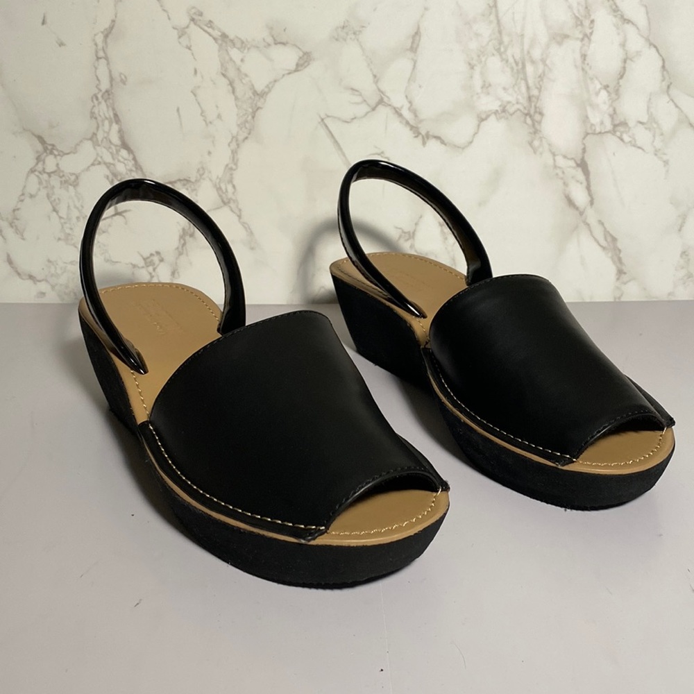 Brand new black strap sandal with open toe and wedge heel.